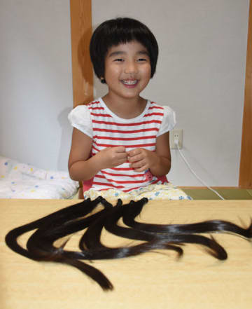 小児用の医療かつらを作ってもらうために髪の毛を切った那須夏帆ちゃんと、31センチの長さにカットされた髪の毛