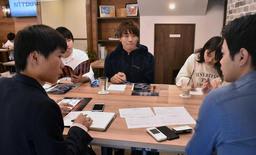 大学前に店を構え、企業と学生をつなぐ「知るカフェ」の交流会。企業の採用担当者(右手前)に質問を重ねる学生たち=西宮市上甲東園3