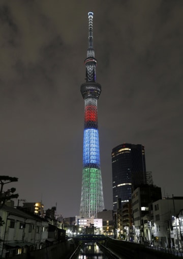 東京パラリンピック開幕まで1年となったのを記念して、シンボルカラーにライトアップされた東京スカイツリー=25日夜、東京都墨田区
